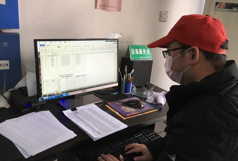 王建对领取口罩的人员核对信息、录入信息